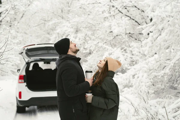 Casal encantador em uma floresta de inverno no fundo de um carro — Fotografia de Stock