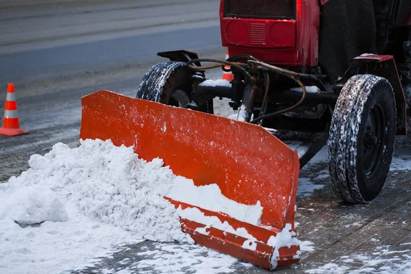 Traktör kardan yolu temizliyor. Kazıcı şehirdeki büyük miktardaki karları temizliyor. — Stok fotoğraf