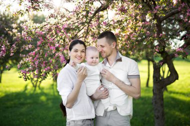 Çocuklu genç bir ailenin portresi. Mutlu bir genç aile yaz günü dışarıda vakit geçirir. Aile yaşamında mutluluk ve uyum. Mutlu aile kavramı