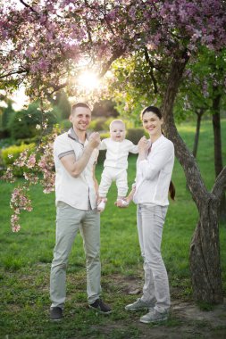 Çocuklu genç bir ailenin portresi. Mutlu bir genç aile yaz günü dışarıda vakit geçirir. Aile yaşamında mutluluk ve uyum. Mutlu aile kavramı