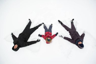 Karla kaplı bir ormanda çocuklu genç bir aile yürüyor..