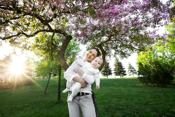 Mooie moeder en baby buiten. De natuur. Schoonheid mama en haar kind spelen in het park. — Stockfoto