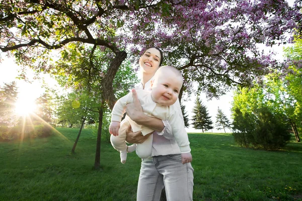 Прекрасна мати і дитина на відкритому повітрі. Природа. Красуня мама і її дитина грають у парку . — стокове фото