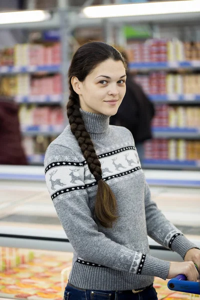 Молодая женщина делает покупки в супермаркете. — стоковое фото