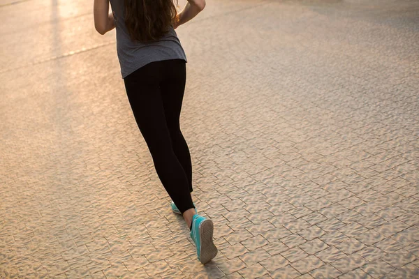 Atleet runner voeten lopen op de weg close-up op schoen. vrouw fitness sunrise jog workout wellness concept — Stockfoto