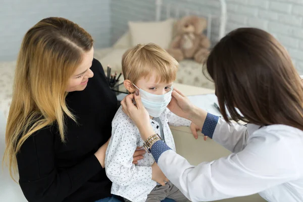 Ein Junge in medizinischer Maske bei einem Arzttermin. — Stockfoto