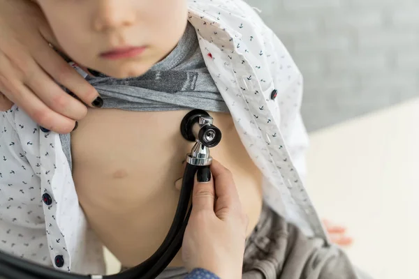Professioneller Allgemeinmediziner Kinderarzt im weißen Uniformmantel lauscht Lungen- und Herztönen von Kinderpatienten mit Stethoskop — Stockfoto