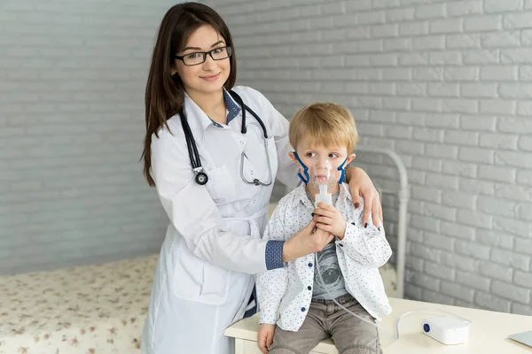 Arzt anwendet medikamentöse Inhalationsbehandlung an einem kleinen Jungen mit Asthma-Inhalationstherapie durch die Maske des Inhalators — Stockfoto