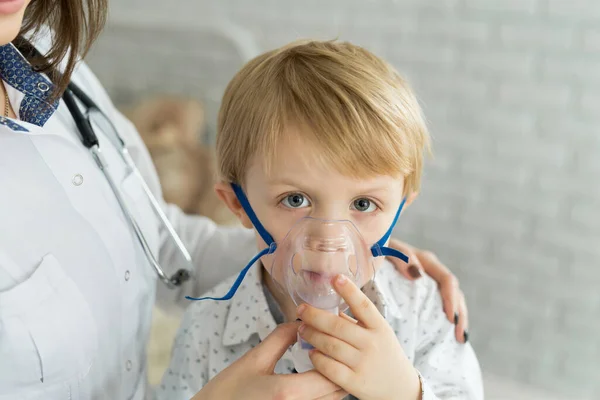 Arzt anwendet medikamentöse Inhalationsbehandlung an einem kleinen Jungen mit Asthma-Inhalationstherapie durch die Maske des Inhalators — Stockfoto