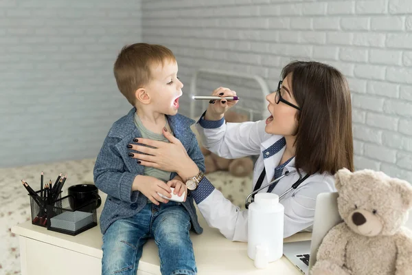 Ärzte untersuchen die Kehle der Kinder. Junge in Kinderarztpraxis — Stockfoto