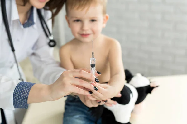 Kinderarzt spielt vor der Spritze mit dem Jungen — Stockfoto