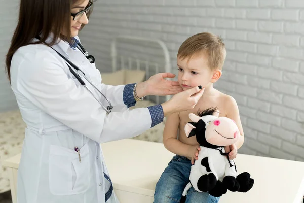 소아과 의사 가 병원에서 어린 소년의 갑상선을 검사하고 있다. — 스톡 사진
