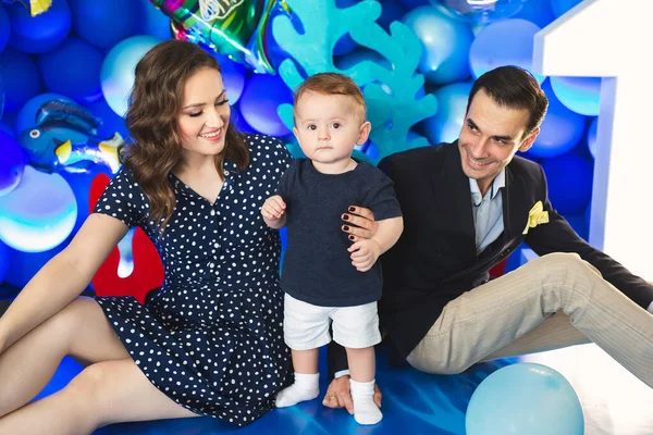 Vader, moeder en zoon op de achtergrond van blauw decor in mariene stijl tijdens de vakantie — Stockfoto