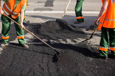 Road Street tamirat sırasında kaldırım makinesinde çalışan işçiler. Sokak yeniden ortaya çıkıyor. Taze asfalt yapısı. Kötü yol..