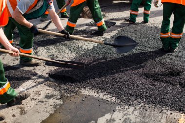 Road Street tamirat sırasında kaldırım makinesinde çalışan işçiler. Sokak yeniden ortaya çıkıyor. Taze asfalt yapısı. Kötü yol..
