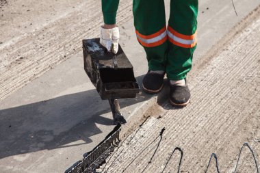 Yol tamiri için asfalt döken adam..