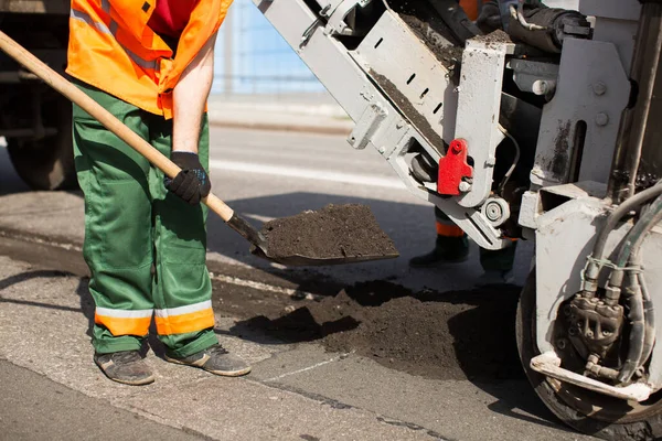 Lavori di riparazione dei lavoratori stradali. lavoro dorme pala il materiale nella macchina — Foto Stock