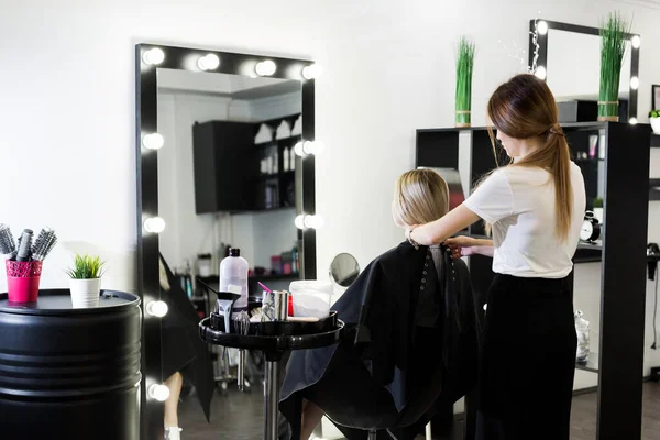 Comb hair. The master in the hairdresser prepares the clients girl to restore the procedures. — Stock Photo, Image