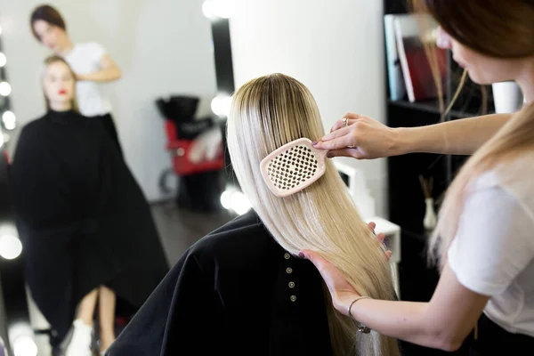 Pentear o cabelo. O mestre no cabeleireiro prepara a menina clientes para restaurar os procedimentos . — Fotografia de Stock