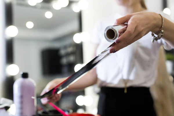 Barbeiro segura a folha para coloração do cabelo . — Fotografia de Stock