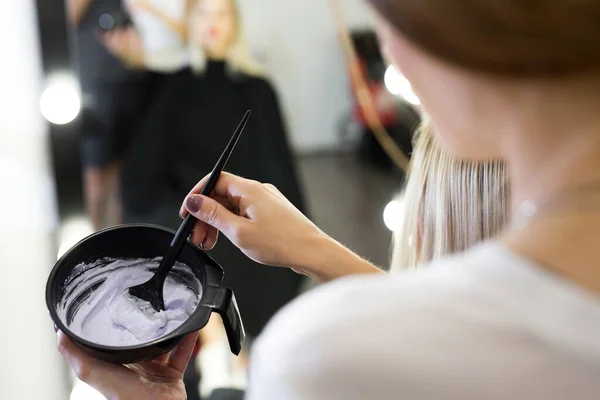 Pintar con un pincel en las manos de un peluquero . — Foto de Stock