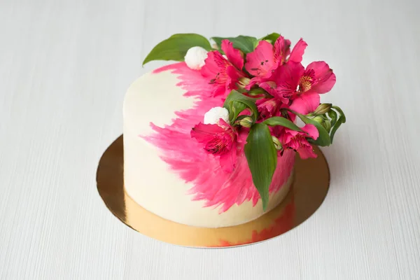 Bolo com decoração de chocolate rosa e flores — Fotografia de Stock