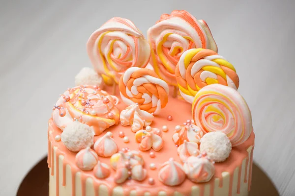 Pastel de color melocotón con merengue, dulces, manchas de chocolate y gominolas — Foto de Stock