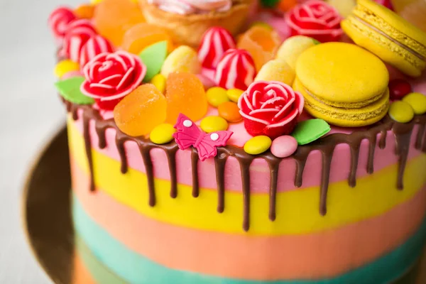 与棒棒糖、糖果、果酱、纸杯蛋糕和兔子一起参加孩子们的生日聚会，蛋糕色彩斑斓. — 图库照片