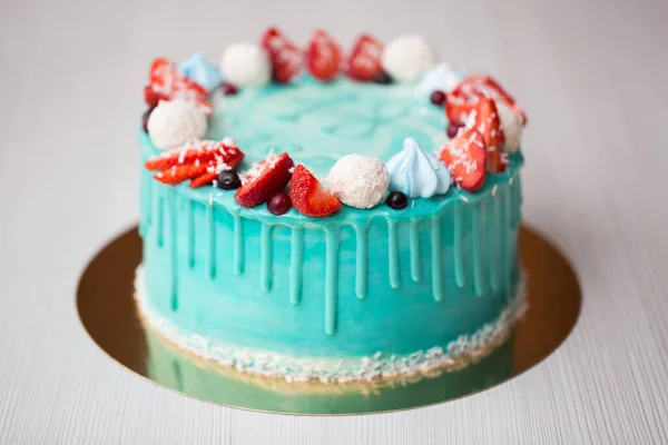 Torta turquesa y azul con fresas, merengue y caramelos . —  Fotos de Stock