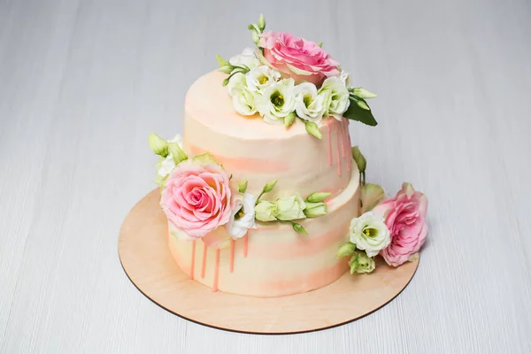 Bolo em camadas com flores frescas e macaroons . — Fotografia de Stock