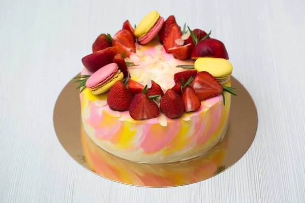 Kuchen gelbe und rosa Kleckse, Erdbeeren, Pfirsiche, Makronen, Rosmarin. — Stockfoto