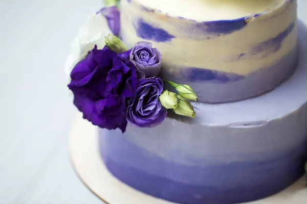 Wedding two-tiered purple cake with fresh flowers