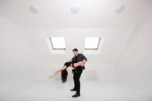 Lindo casal dança bachata no fundo branco no estúdio . — Fotografia de Stock