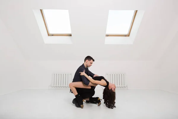 Lindo casal dança bachata no fundo branco no estúdio . — Fotografia de Stock