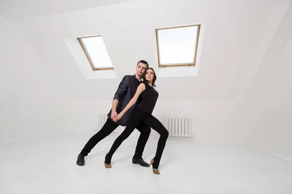 Lindo casal dança bachata no fundo branco no estúdio . — Fotografia de Stock