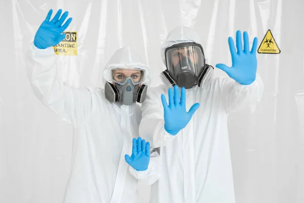 의료 복을 입은 두 명의 의사와 얼굴 마스크를 쓴 한 명의 남녀 그리고 장갑낀 손 이 정지 신호를 보여 주는 그림. COVID-19 개념을 중지하 십시오. 유행하는 코로나 바이러스 — 스톡 사진