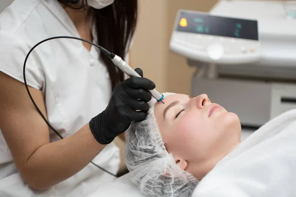 Kosmetyczka terapeuta sprawia, że leczenie laserem do twarzy młodych womans w klinice urody Spa. Zbliżenie proces laserowe usuwanie naczyń krwionośnych ze skóry. — Zdjęcie stockowe
