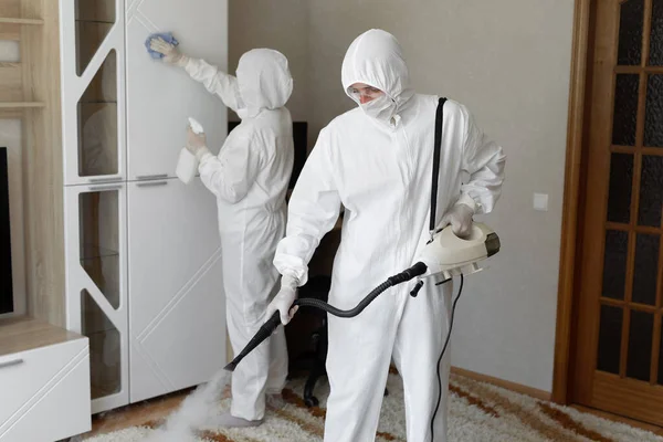 Disinfezione da coronavirus. Persone in pericolo che effettuano la disinfezione in appartamento, spazio di copia, disinfezione a vapore caldo. — Foto Stock