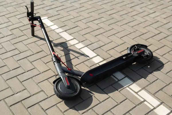Uma scooter elétrica está deitada na calçada. — Fotografia de Stock