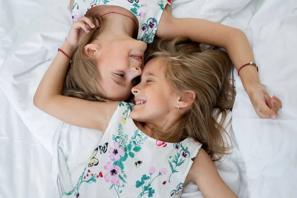 Dos hermanas gemelas yacen en la cama —  Fotos de Stock