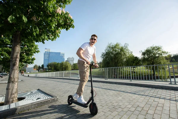 Człowiek jeździ na skuterze elektrycznym po mieście.. — Zdjęcie stockowe