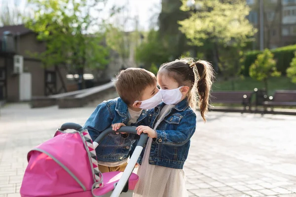 Kinder küssen sich in Schutzmasken. Coronavirus, covid-19. — Stockfoto