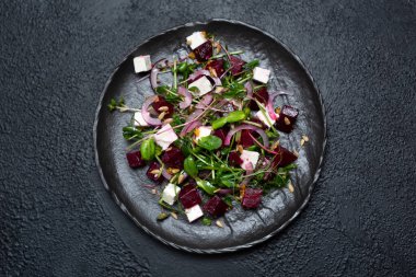 Mikro gren salatası, pancar kökü ve peynir. Siyah arka planda taze soğan ve tohumlar. en üstteki görünüm