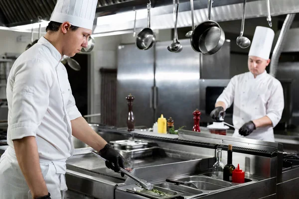 Cucina moderna. Gli chef preparano i piatti sul fornello nella cucina di un ristorante o di un hotel — Foto Stock