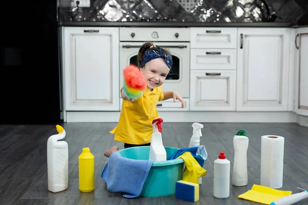 Mutfakta toz fırçası ve deterjanı olan küçük bir ev hanımı. — Stok fotoğraf
