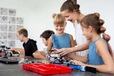 Eğitim, çocuk, teknoloji, bilim ve insan kavramı - grup robotlar robot okul ders bina dizüstü bilgisayar ile mutlu çocuk.