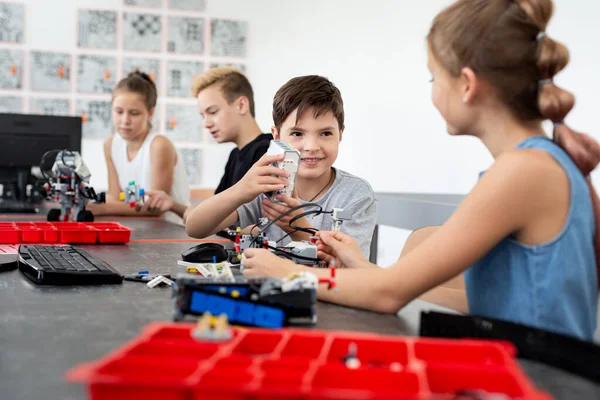 Schoolkinderen programmeren een robot in de klas. — Stockfoto