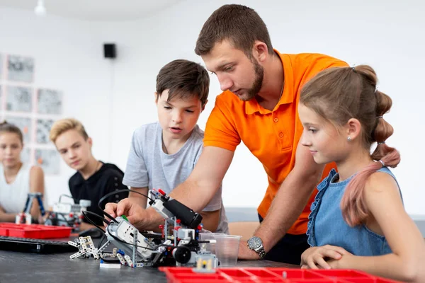 Kinderen werken met leraar op hun robot onderwijsproject. — Stockfoto