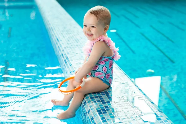 Liten flicka skrattar i poolen på en simlektion — Stockfoto