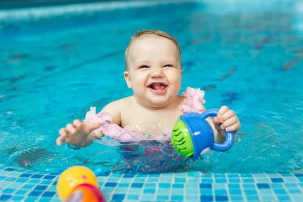 Kleines Mädchen spielt mit hellem Spielzeug im Pool — Stockfoto